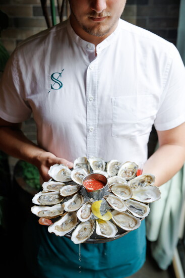 Skipjack Oyster server with a variety of oysters. Image by Skipjack Oyster.