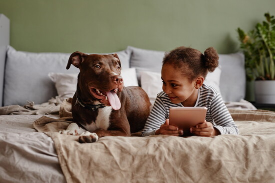Girl with a dog on a bed.