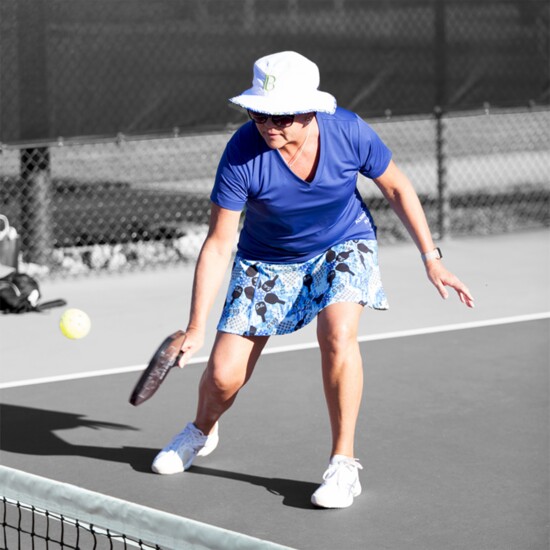 Pickleball Bella’s Graffitti 2 A-line skort, V-neck tee, and a Dink 1 Bucket-Boonie Hat.