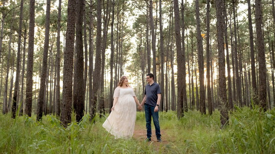 A quiet walk through the pines creates a natural setting for a relaxed family portrait.