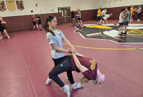Mia Perez & Quinly Vondy practice their back arches for throws. Wrestling is creating more pathways for female athletes.