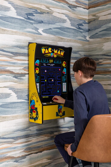 The Quisenberry’s son tries his luck on the Pac-Man video game, nestled in the corner of their playroom