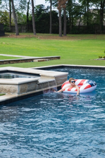 A refreshing pool surrounded by a lush lawn 