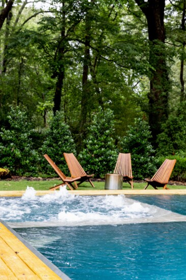 Chairs surrounding fire pit bubbling hot tub in the background