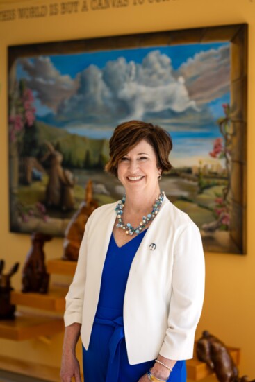 Jennifer Lamb standing in front of "Bunny World" by Artist Rachael McCampbell.