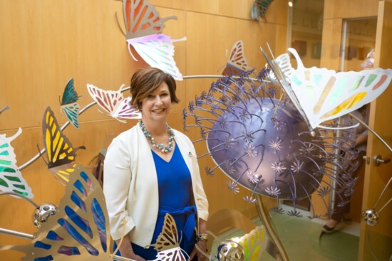 Jennifer Lamb standing in "Kaleidoscope", Artist Yvonne Bobo Location: NICU Entrance / Light Court