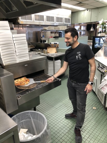 Andreas Vellios takes a pizza from the oven at Tally Ho Restaurant.</p>