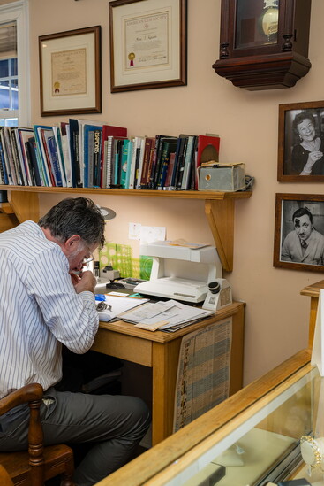 Alan works at his desk besides photos of his parents.