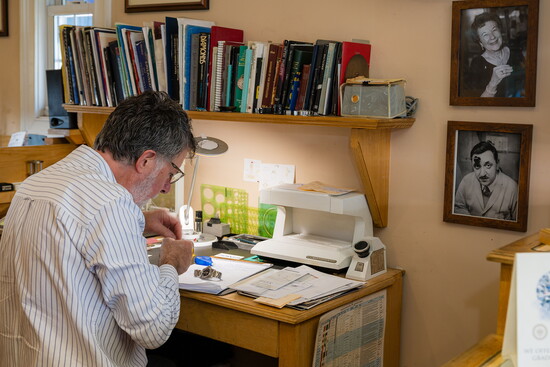 Alan works at his desk besides photos of his parents.