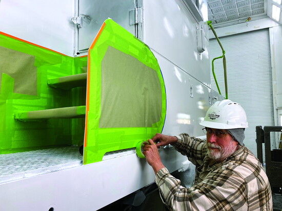 Mike Brusky finishes the masking in preparation for the red coat of paint. 