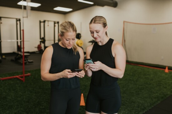 Emily Hawk and Monica Taplin using the Trainerize app