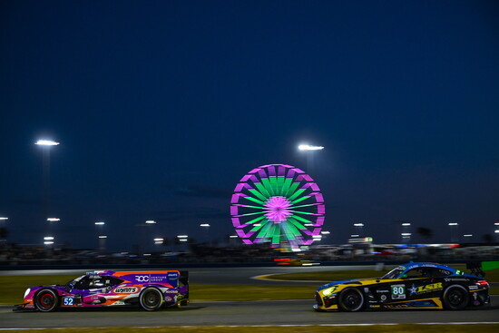 Cars race at night in the infield of Daytona International Speedway during the IMSA Rolex 24 