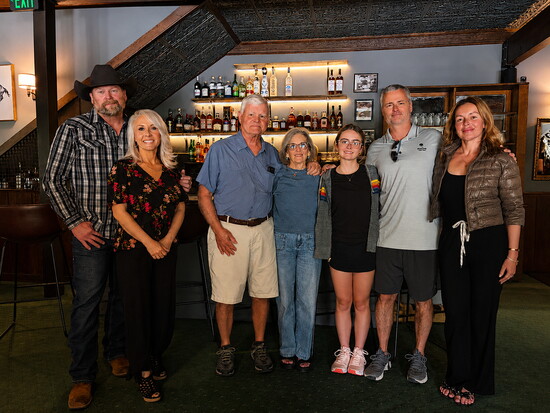 (L to R) New owners Edward Miller and Athena LeBon with former owners Tom, Lynn, Natalia, Max, and Tatyana Ludwig.