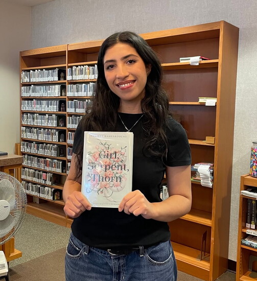 Sienna Tracey showcasing the first pick for the new middle schooler book club at the Westwood Public Library