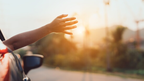 Person holding their arm out of the passenger side window.