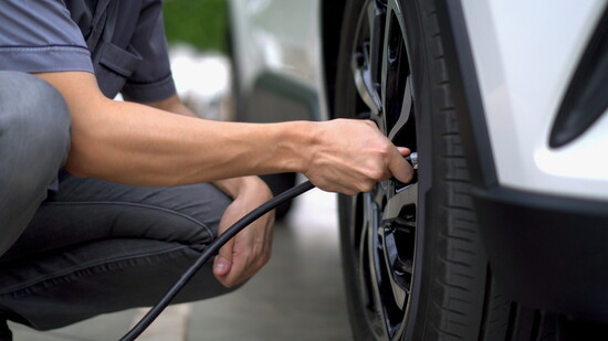 Person filling a tire with air. 