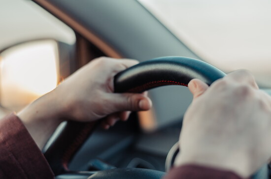 Hands on a steering wheel. 