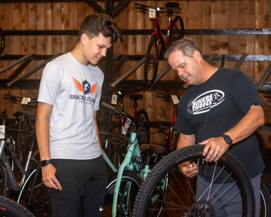 David Harding teaches Kaedyn Hinkle about proper bicycle tire pressure.