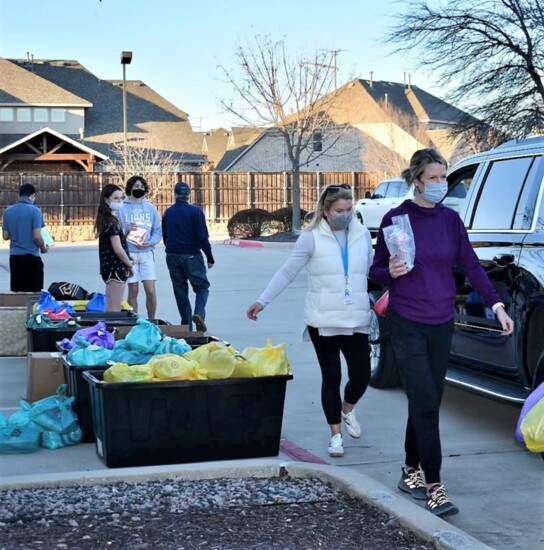 Volunteers distributing packs at drive-through distribution.