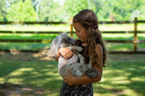 Charlotte cuddles Ori, a puppy with hydrocephalus.
