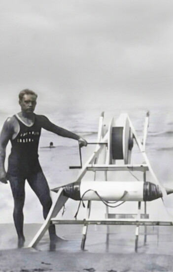 George Freeth stands beside his life-saving torpedo invention, the precursor to today’s rescue buoy.