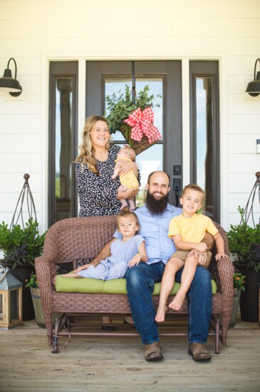 Dr. Cameron & Dr. Melanie Wolf with their children on their front porch.