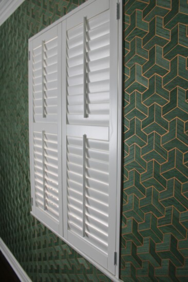 A unique blend of green stained veneer crafted in modular formation against the classic white shutter.