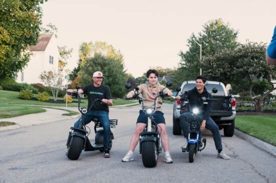 Phat Scooters Co-founder Peter Johnson, along with New England Patriots player Tedy Bruschi, and his son, Dante (middle)