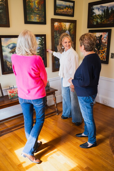 Mary John Denton Tino (center) helps customers in one of the gallery rooms