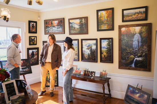 Robert A. Tino (center) chats with customers in one of the gallery rooms