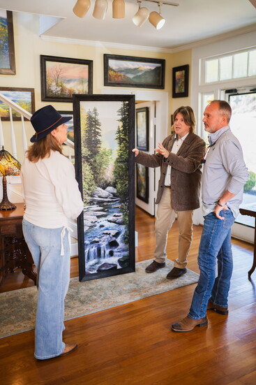 Robert A. Tino (center) chats with customers in one of the gallery rooms