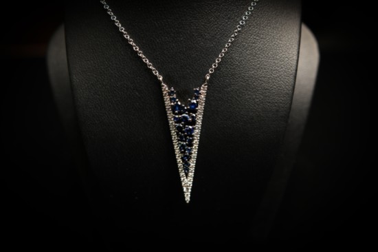 14 karat white gold diamond and blue sapphire v-shape fashion necklace. Prong set with 45 round brilliant-cut diamond set with 19 blue round sapphires. $1,135