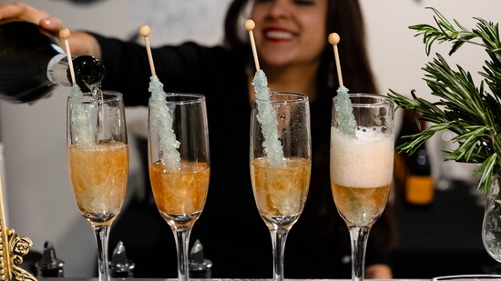 MayaLou pours champagne over rock candy stir sticks to create a unique cocktail to match a client’s special event.