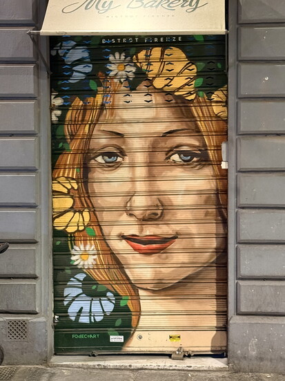 On a shop door in Florence, a pop-art depiction of Botticelli’s Face of Flora, from his Primavera painting, which is housed in the Uffizi Gallery.