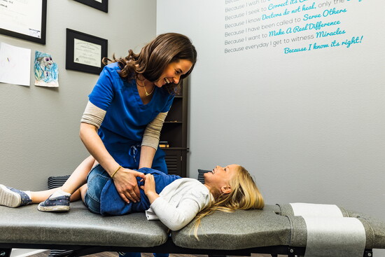 Dr. Toni in 2022 sharing a joyful moment of care with a young patient, reflecting the family-centered approach at New Beginnings. Black Iron Photography.