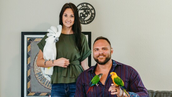Russow and his wife with their three birds, Willie, Mango, and Oscar. 