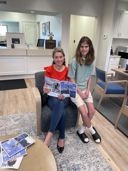 Michelle (last name) and her daughter (name) relax in the bank lobby