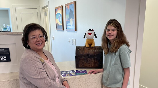 Rosey and (name) visit the teller counter at Hawthorn Woods Community Bank