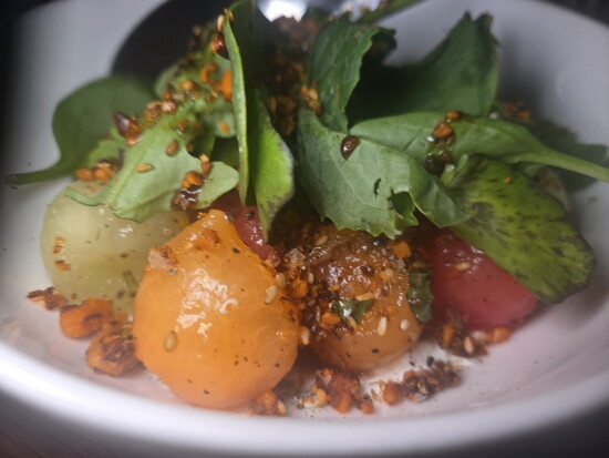 Melon salad with mint, burnt honey vinaigrette, and walnut dukkah over labneh at Thompson Italian. Photo Credit: Jennifer Waldera