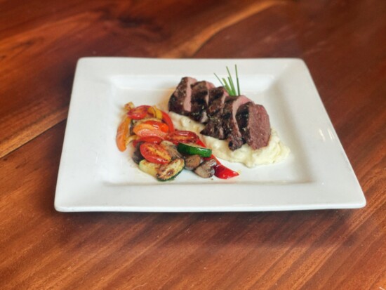 Pan-seared steak with mashed potatoes and sautéed vegetables