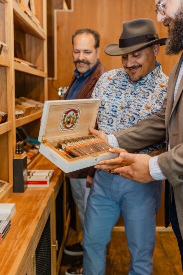 Dean Cavero, Realtor learn about their cigar selections from Elier "Albert" Alberto, owner.