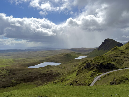 Grassy slopes lead down to a group of hidden lochans (ponds) near the Quiraing, the Isle of Skye.