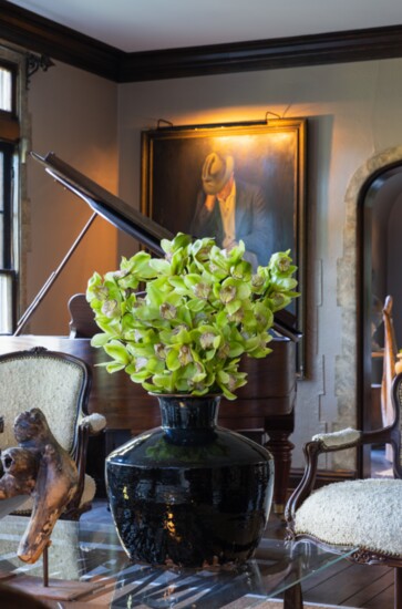 Kevin’s home is an ideal setting for the artistry of floral design. Here, a Depression-era painting is the backdrop for an urn filled with orchids.