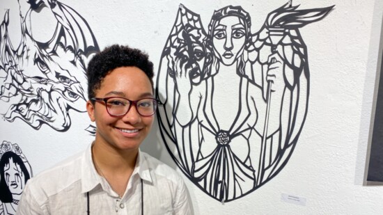 Rachel Hawkins poses with some of her art at the Tennessee Governor's School for the Arts at MTSU during June 2021.