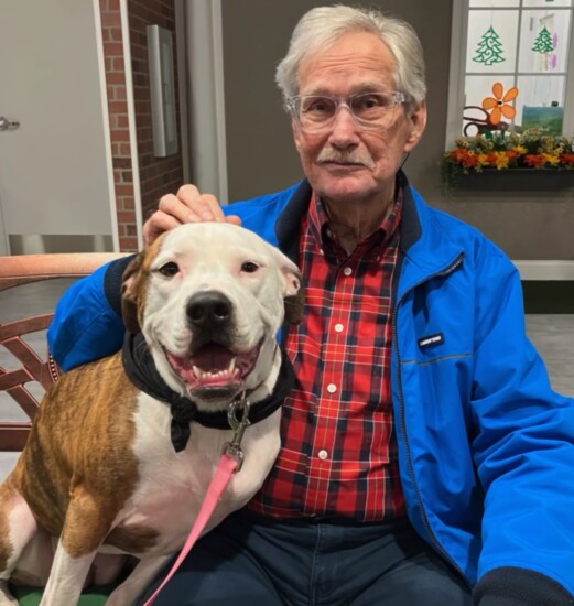 A Town Square member enjoys a visit from one of The Pit Crew's therapy dogs