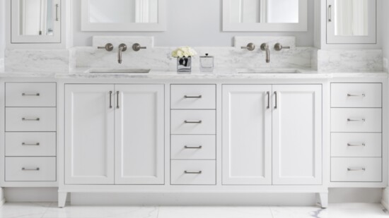 In the master bath, extra-deep medicine-like cabinets — created by Petrucci Homes — flank the vanity. A custom backsplash wraps along the angles of the cabinets