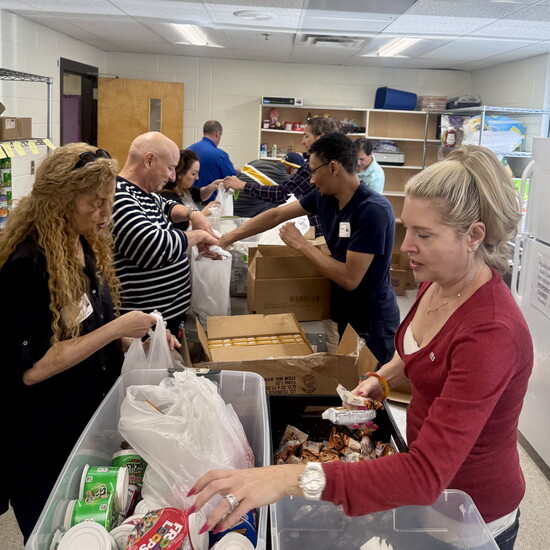 Rotarians and volunteers join forces to pack weekend meal bags for Green Acres Elementary students through the Backpack Buddies program.