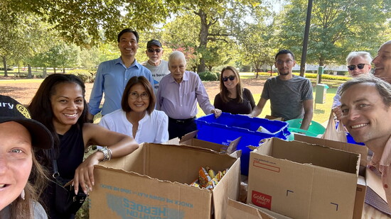 Fellowship in action: Smyrna Rotary members gather under the trees to sort and prepare meal bags together.