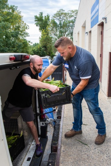 Ryan Allnutt of Thin Line Home Inspections (in blue) partner of The Lahey Group and NourishNow CEO Brett Meyers unload the weekly meal packages.