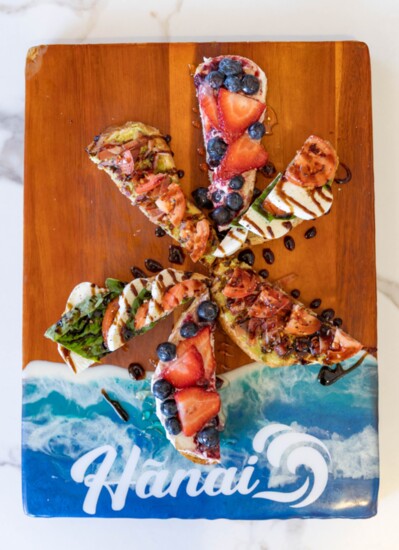 A selection of Hanai Coffee + Cocktails toasts on a locally made custom wood board. 